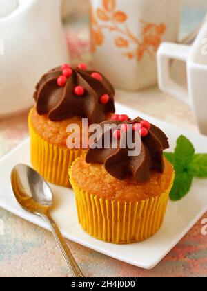 Two cupcakes with chocolate. Stock Photo