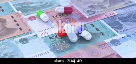 China healthcare and medicine budget. Pills on Chinese yuan renminbi bill banknotes background. Health and medication cost. 3d illustration Stock Photo