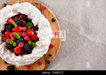 Delicious Pavlova cake with meringue topped and fresh berries Stock Photo