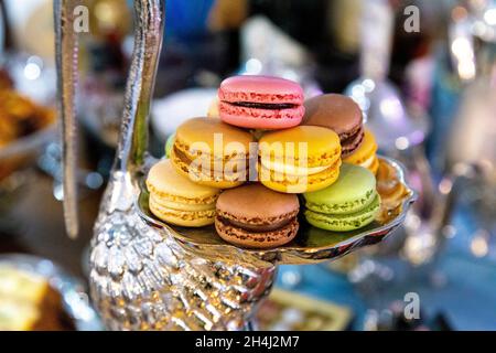 Selection of macarons on a silver, decorative heron tray at dinner party Stock Photo