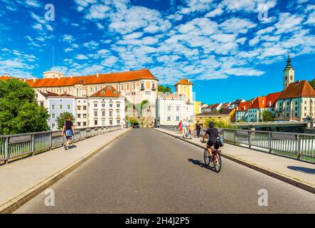 Steyr - June 2020, Austria: A man is riding a bike across the bridge towards the center of the beautiful Austrian city of Steyr Stock Photo