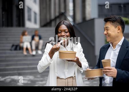 Business people eat on background of colleagues Stock Photo