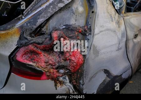 Burn-out headlight close-up. Burnt car's door in the street close-up. Riot, civil protestRiot, civil protest, hooliganism, criminal in the city. Explo Stock Photo