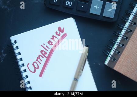 close up of hand written Compliance text on notepad  Stock Photo