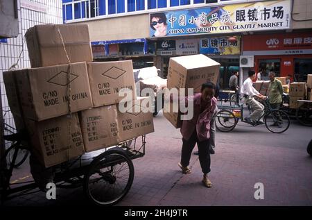 Consumer goods destined for the English-speaking world. Made in China is printed on large brown boxes carried off by a market trader in the small commodities Yiwu market which is the largest market in the world with an annual turn over of over $1billion. Yiwu, Zhejiang Province,  Republic of China, 2001, 2000s, HOMER SYKES Stock Photo