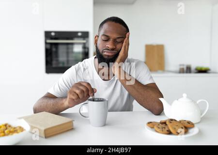 Black man suffering from insomnia drinking coffee Stock Photo