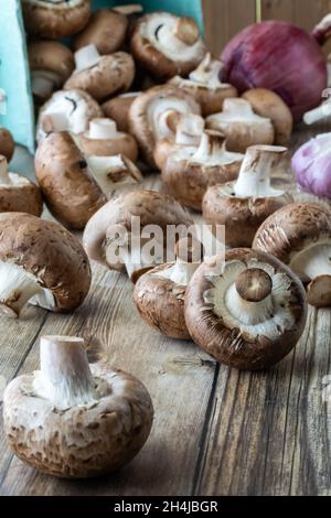 Fresh cremini mushrooms spilling out of a cardboard produce box. Stock Photo