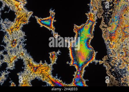Extreme macro photograph of Vitamin C crystals forming abstract modern art patterns, when illuminated with polarized light, under a microscope Stock Photo