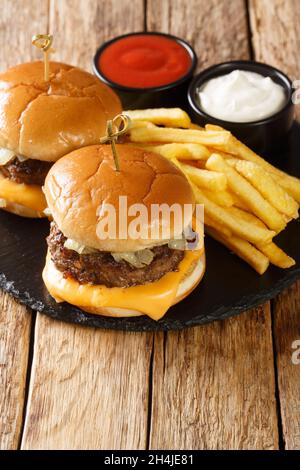 Butter beef burger with French fries close-up on a slate board on the table. Vertical Stock Photo