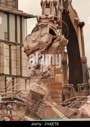 Digger claw ripping up reinforced concrete on a demolition site. Stock Photo