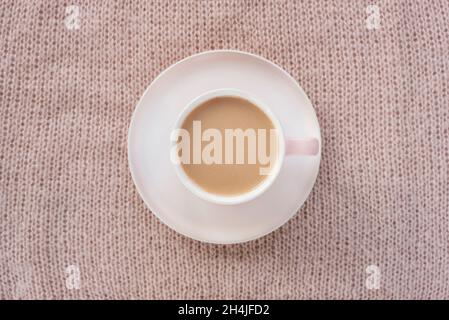 Coffee cup on warm knitted plaid background. Winter concept. Top view, flat lay. Stock Photo