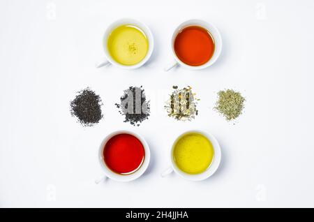 Collection of different teas in cups with tea leaves on a white background. Stock Photo