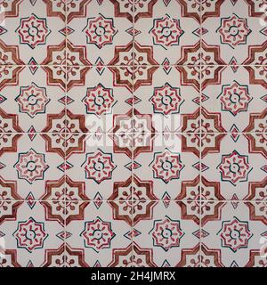 Fragment of building wall with colorful ceramic wall tiles. Azulejos close up. Traditional Portuguese architecture. Abstract decorative background. Stock Photo