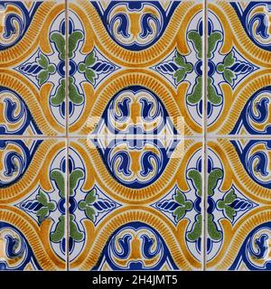 Fragment of building wall with colorful ceramic wall tiles. Azulejos close up. Traditional Portuguese architecture. Abstract decorative background.