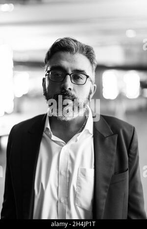 Handsome hispanic man wearing business clothes and glasses bored ...