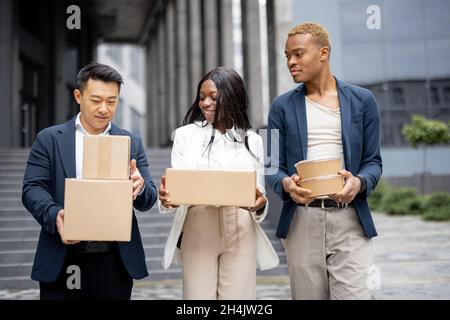 Businessteam with parcels and food walking in city Stock Photo