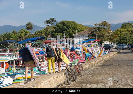 Brazil, Rio de Janeiro state, Paraty, colonial city founded in 1667 to export Brazilian gold, The crew on the move to find a beach where one can surf, In the port of Paraty, the boats at the quayside offer an incredible palette of colors, Stock Photo
