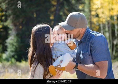 Portrait of a happy couple standing in the forest with their baby daughter, California, USA Stock Photo