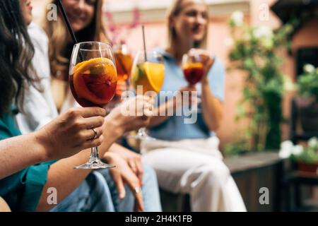 Three women sitting outdoors enjoying summer cocktails, Belarus Stock Photo
