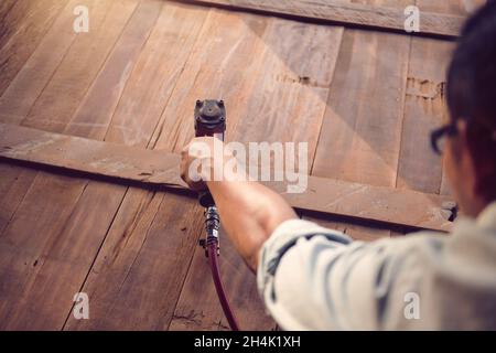 Close-up of a carpenter making furniture using a nail gun Stock Photo