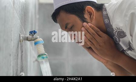 Close-up portrait of a man taking ablutions before prayer at a mosque Stock Photo