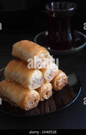 An image of Turkish baklava and a cup of tea in a low key. Vertical shot. Stock Photo