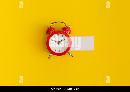 Red alarm clock on yellow background Stock Photo