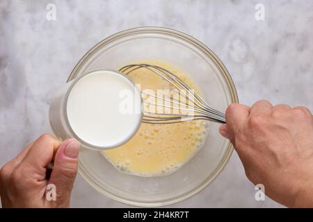 Hand Mixer with Eggs in a Glass Bowl on a Reflective White Background ...