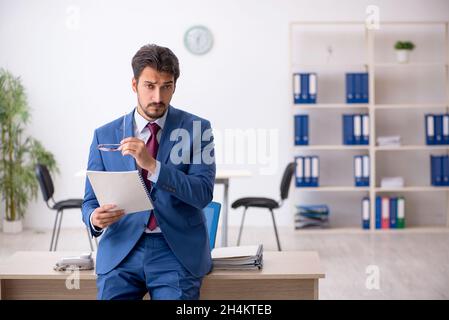 Young businessman employee reading paper at workplace Stock Photo