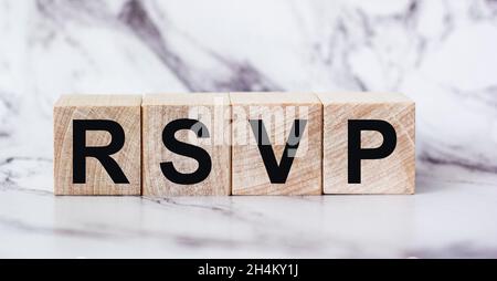 The abbreviation rsvp request for a response from an invited person is written on wooden blocks Stock Photo
