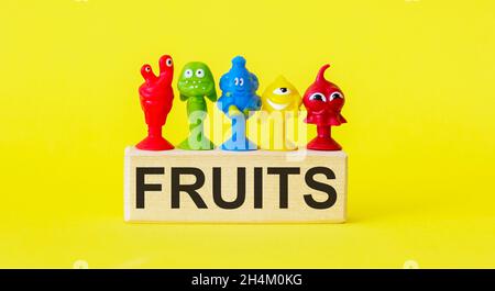 wooden toy cubes with letters. Fruit concept on yellow background Stock Photo