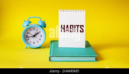 Habits word written on notepad and yellow background Stock Photo