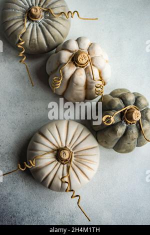 White handmade ceramic pumpkins as a Thanksgiving card on same color concrete background Stock Photo