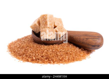 Brown sugar in wooden spoon, isolated on white background. Heap of cane sugar crystals and sugar cubes. Stock Photo