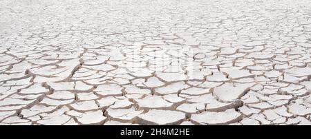 Cracked white clay, dried lakebed surface texture. Panorama with diminishing perspective and deep focus Stock Photo