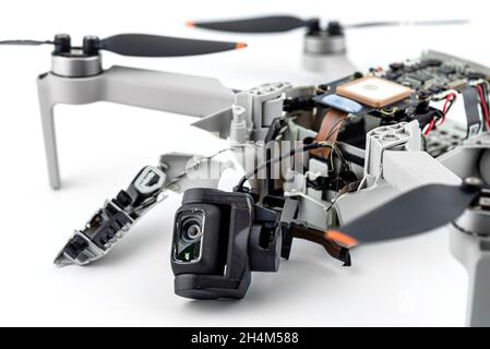 A broken drone after a fall with torn cables and a broken camera, isolated on a white background. Stock Photo