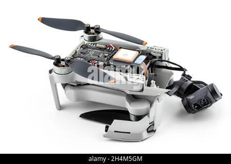 A broken drone after a fall with torn cables and a broken camera, isolated on a white background. Stock Photo