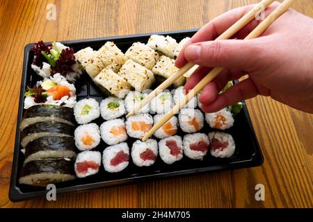 takeaway assortment of sushi rolls in a plastic box