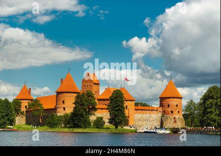 Lithuania. View on Trakai castle across lake and white yacht under sail. Stock Photo