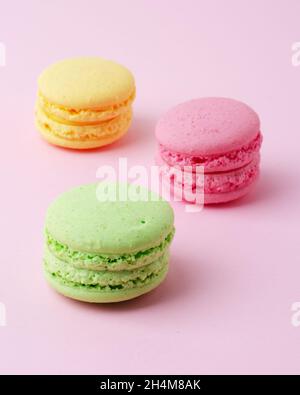 Cake macaron or macaroon colorful almond cookies, pastel colors on a pink background Stock Photo