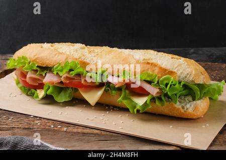 Sandwich with ham, tomato and cheese on a wooden background Stock Photo