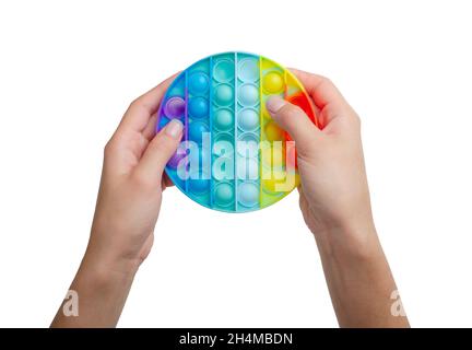 Colorful antistress sensory toy fidget push pop it in girl's hands isolated on a white background Stock Photo
