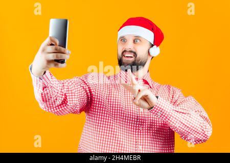 cheerful man in a santa claus hat makes christmas selfies Stock Photo