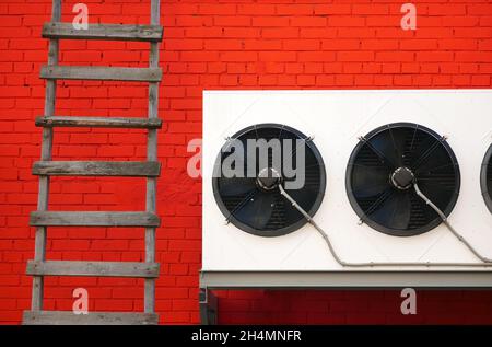 Red brick wall with industrial propellers and standing wooden staircase Stock Photo
