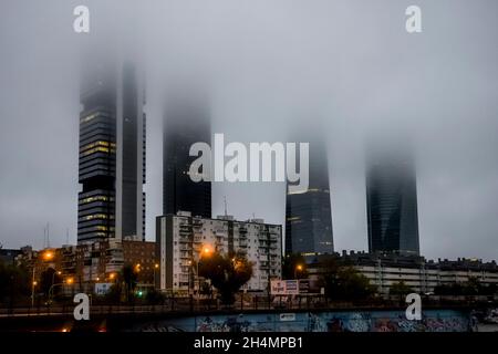 The Cuatro Torres Business Area with the four towers surrounded by fog in the morning as seen  from Chamartin railway station, in Madrid, Spain. Stock Photo