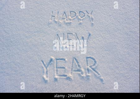 Happy New Year text draw on snow for holiday card Stock Photo