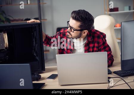 Portrait of attractive experienced focused trendy guy repairing part detail pc upgrade processor at office workplace workstation indoor Stock Photo
