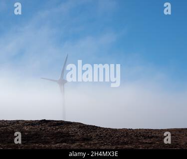 Wind turbine emerging from the mist. Corrimony Wind Farm, Highland, Scotland Stock Photo