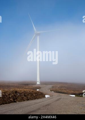 Wind turbine emerging from the mist. Corrimony Wind Farm, Highland, Scotland Stock Photo