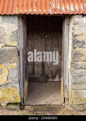 Entrance vestibule to the Corrimony Bothy near Cannich, Highland, Scotland. There is no toilet in the bothy but a shovel is provided. Stock Photo